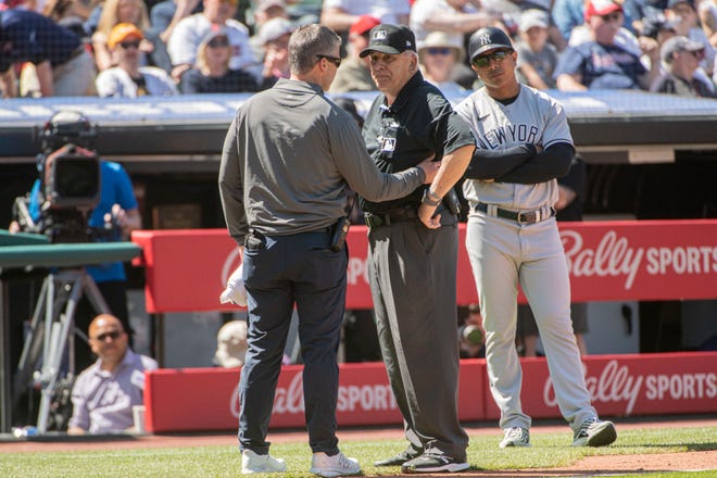 Umpire Larry Vanover is attended to by a Cleveland Guardians trainer after being hit by a throw from the outfield during the fifth inning of a baseball game in Cleveland, Wednesday April 12, 2023. Vanover left the game because of the injury. (AP Photo/Phil Long)