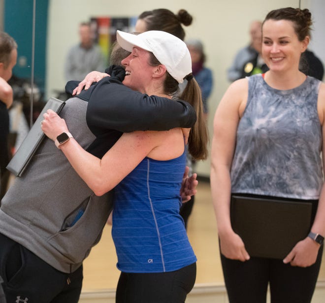 Joanna Bruno gets a hug from Lawrence Township resident Joey Mohr as Hailey Hon looks on after spin class members were recognized for saving Mohr's life during a cardiac event at the Paul and Carol David Jackson Township YMCA.